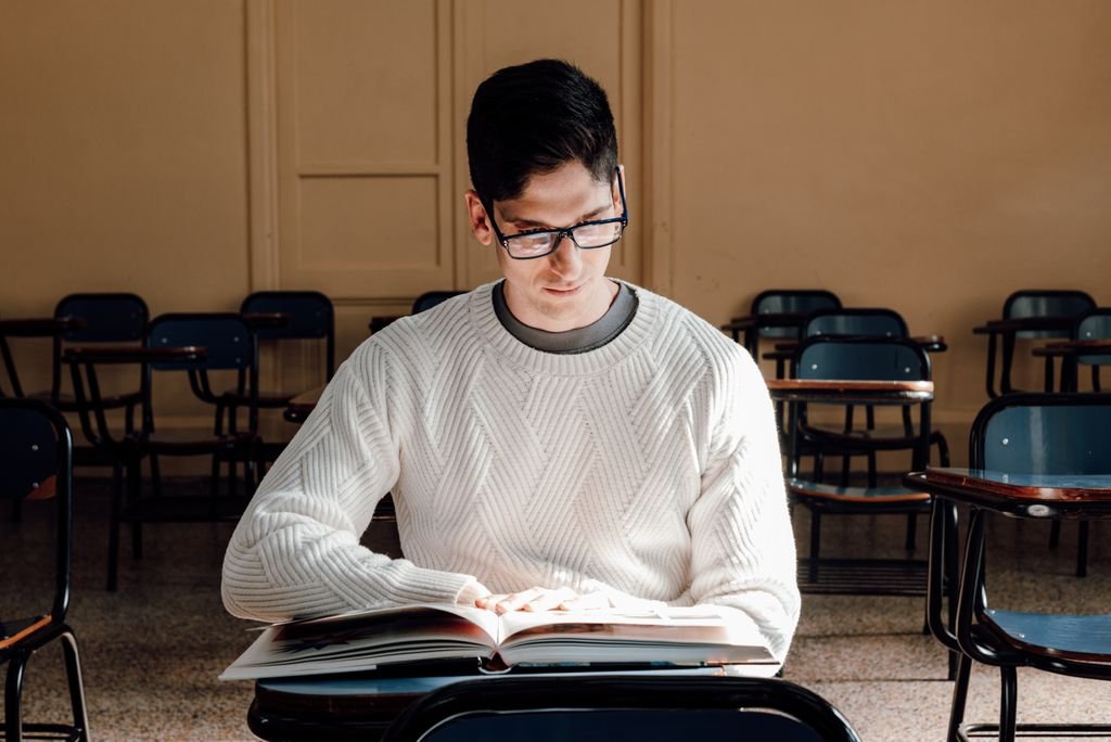An adult student reading a book in an empty classroom in Buenos Aires, Argentina.